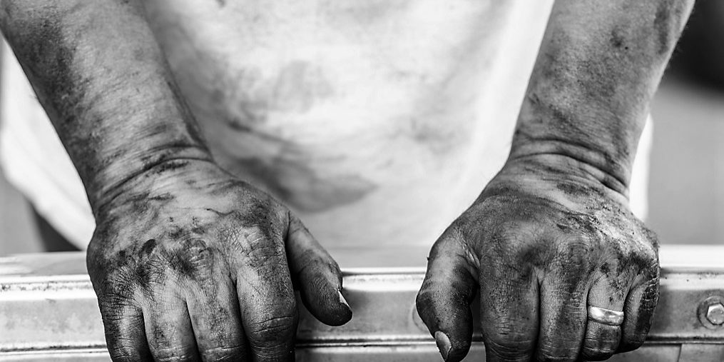 A man fixes his own car. Resting.